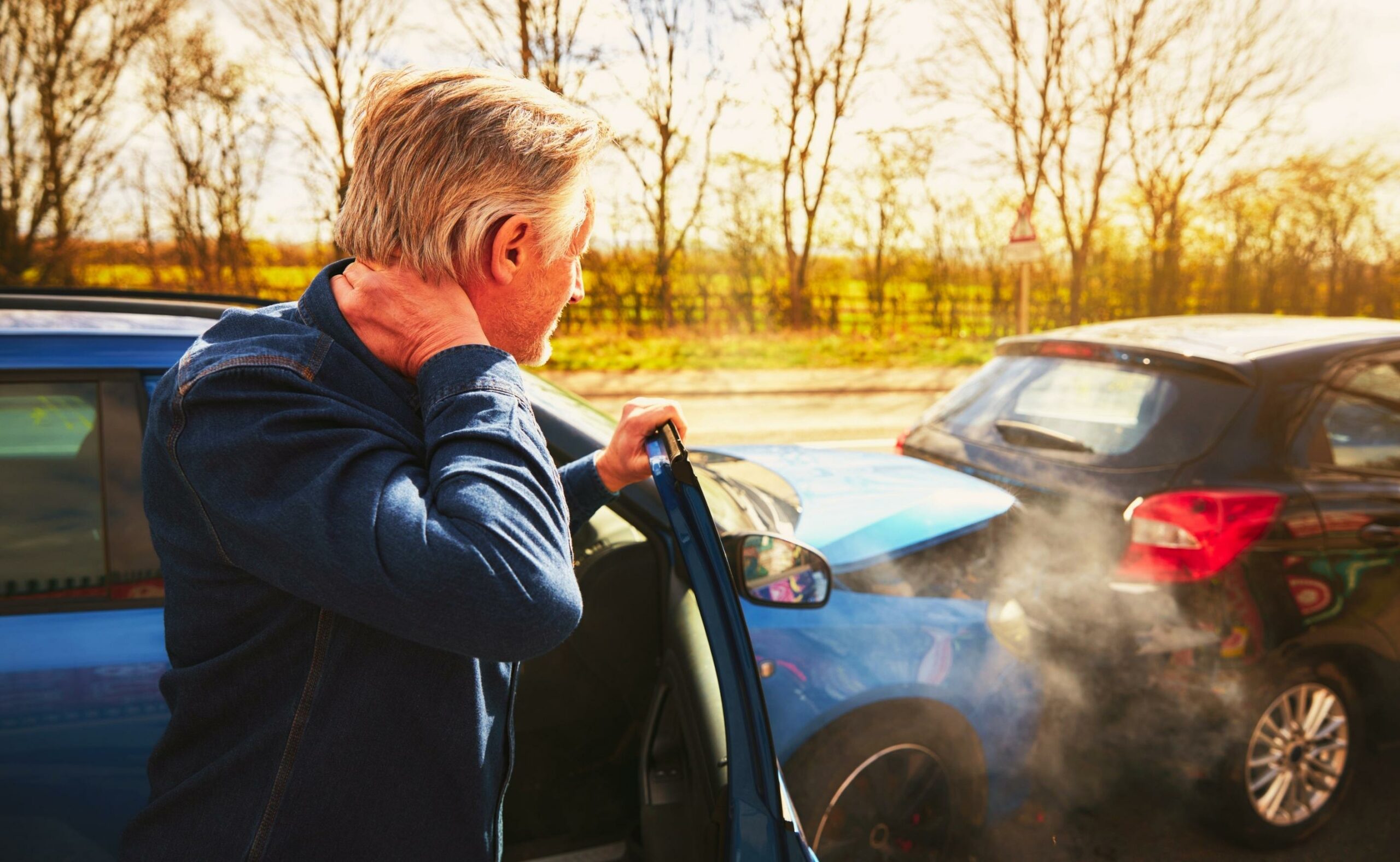 man looking at a crash of two cars