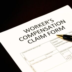 Workers' compensation claim form application with pen on desk