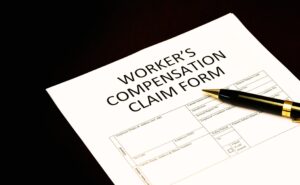 Workers' compensation claim form application with pen on desk