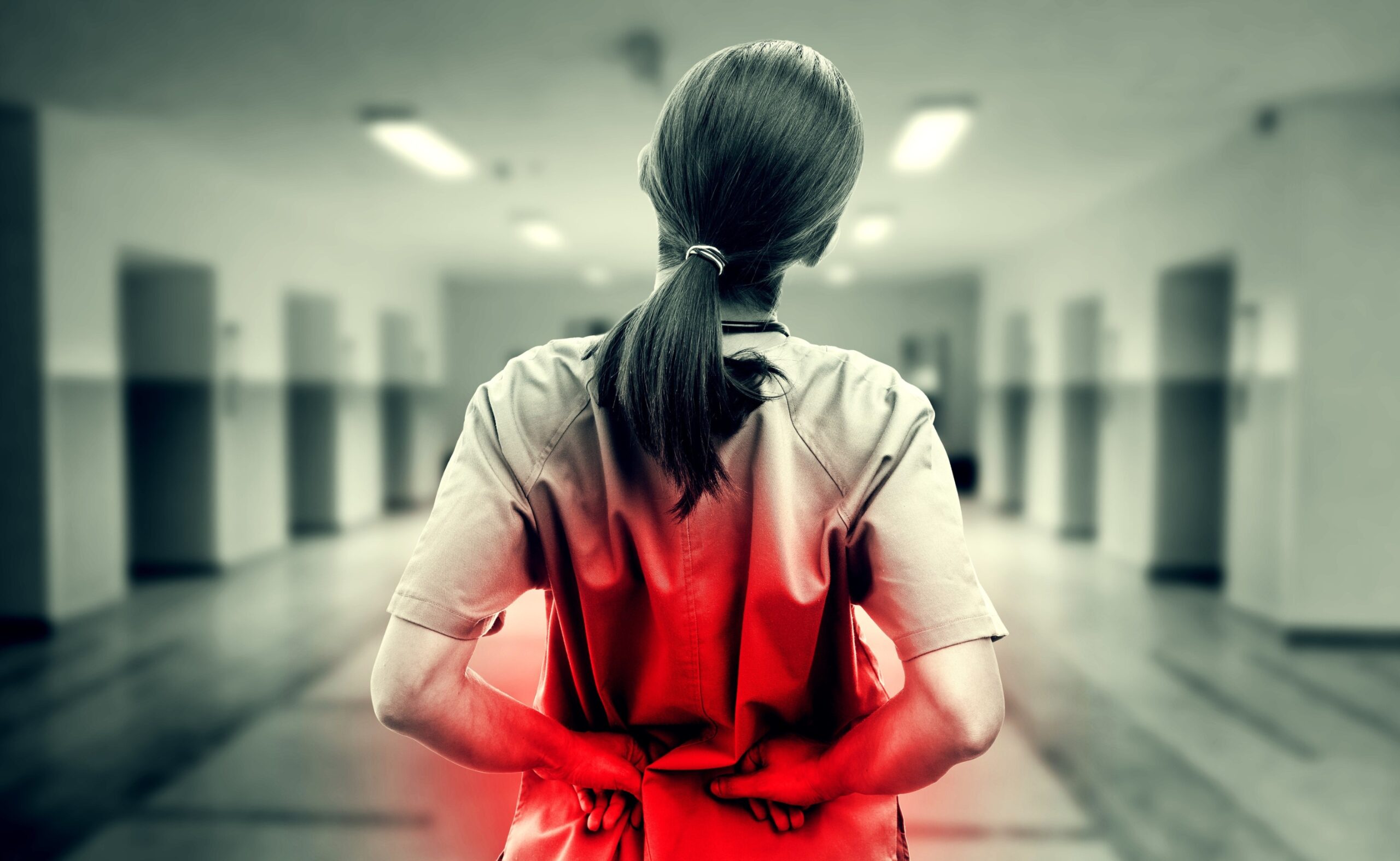 Nurse touching hurting back in black and white
