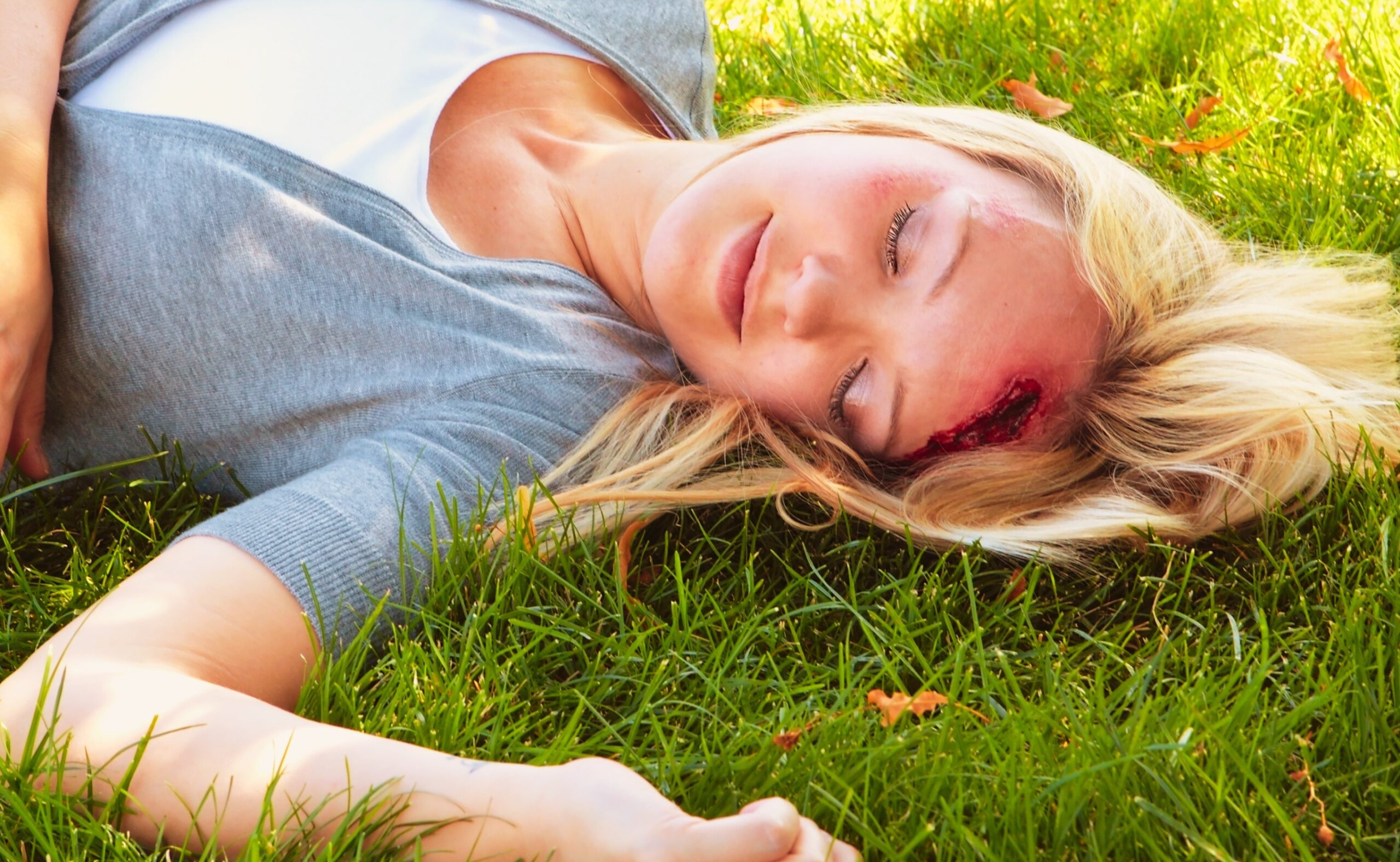 A woman lying on the group with a head injury