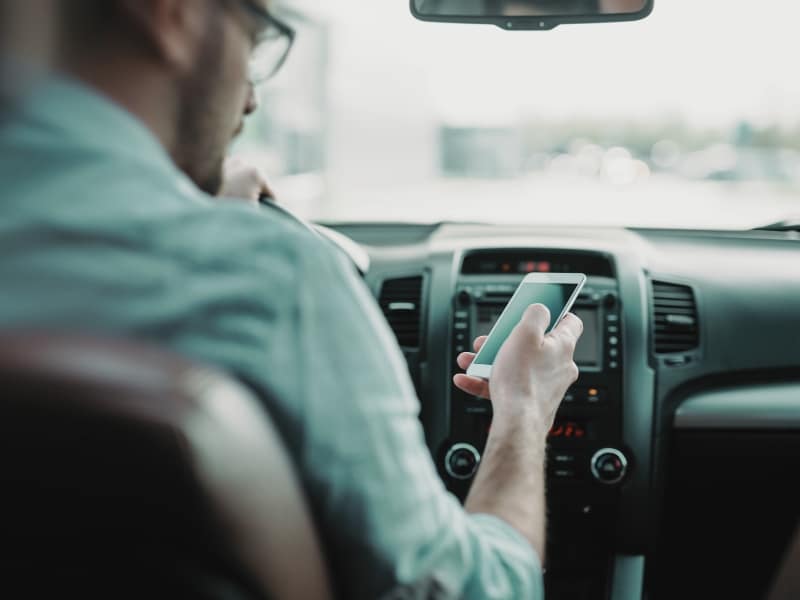 man using phone while driving the car. Concept of Types of Distracted Driving in Las Vegas