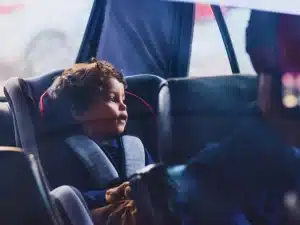 Little boy sitting in a car seat while his father drives.