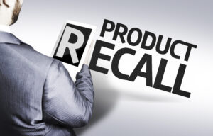 Product recall with a man in suit holding the letter "R" on a tablet device.