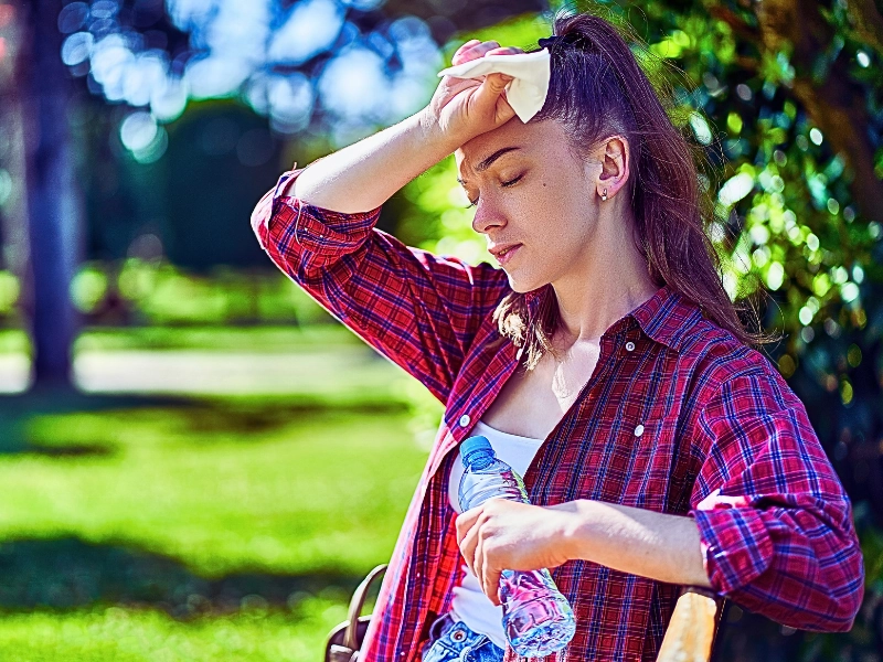 Young unhappy tired woman with cold refreshing water suffering from hot weather. sue for heat stroke