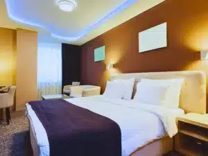 Modern hotel bedroom with warm lighting and blue accents. scorpion