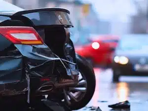 Damaged rear end of a dark car involved in collision.