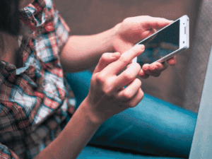 A person touching his cellphone insurance company use your social media